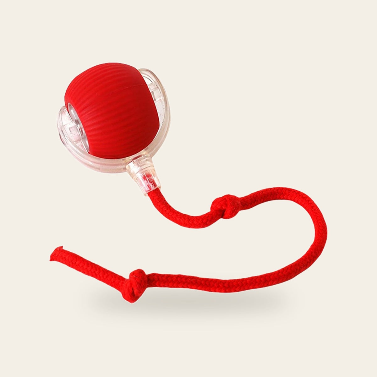 Self-Rolling Cat Ball with red rope tail on a plain sand background