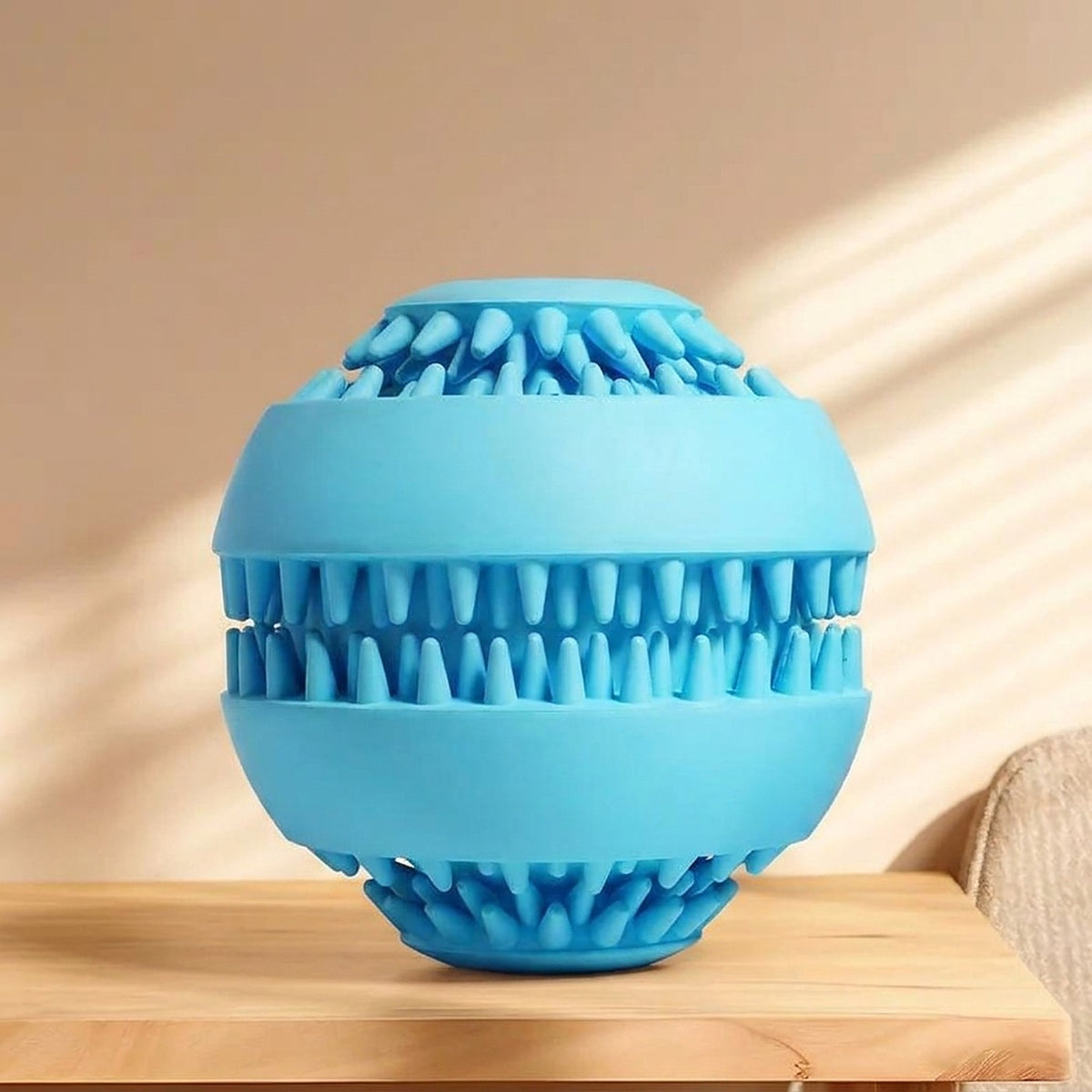 Hauloft treat ball, blue, on a wooden floor