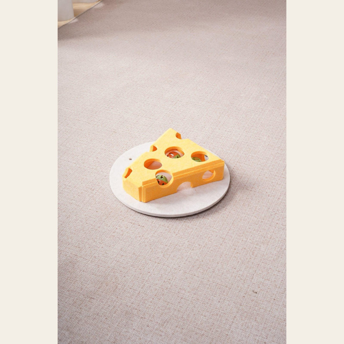 Yellow Hauloft cat puzzle box on its round base on a carpet